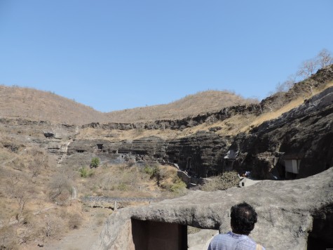 Ajanta caves from eastern entrance on the morning of Buddha Purnima, 25 May 2013.  Anirudh stepping on to the gateway.  River Waghora has dried up beneath in the late summer.